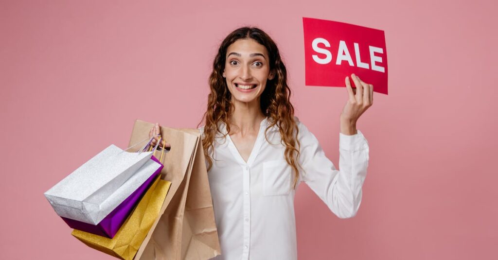 Joyful woman holding shopping bags and a sale sign, ready for a shopping spree on a pink background.
